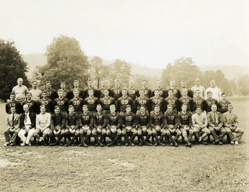 First row: Max Kramer, manager; Art Smith, trainer; Eddie Hirschberg, assistant coach; Sam Mandich, Charley Seabright, John Carliss, John Rockis, John Shonk, Bob White, Bob Mellace, Joe Siko, Glenn Ellis, Bill Jennings, Ray Carnelly, freshman coach; Dr. Sam Morris, team physician, Harry Riley, manager. Second row: Pete Antolini, Charley Stansbury, John Morris, Tom Gillooly, Norm Laughlin, Howard Lewellen, Hank Goodman, Frank Kimble, George Sharp, Vic A'hearn, Steve Narick, Charles Harris, Quentin Barnette, Don McCann, Joe Butta. Third row: Bill Kern, coach; Mike Nicksick, backfield coach; Vincent Cimini, Chappy Ballato, Bill Grier, Kenny Fryer, Allan Martin, Vic Peelish, Bill Gardner, Dave Bayer, Dick McElwee, Peter Yost, Henry Sterle, Frank Kutz, guard coach; Erratt Rodgers, scout. Print number 209.