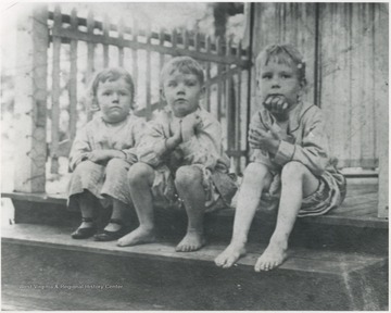 (From left to right) Dorothy Daly, Robert Turner, and Andy Timberlake sit on the porch steps. 