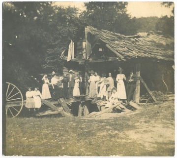 A group of unidentified subjects pose infront of the old mill. 