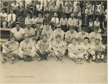 Unidentified players sit together in front of the on-looking crowd. 