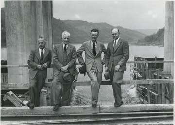 From left to right, Orval Charles, the engineer in charge, Henry Auhl, Robert A. Thompson, the assistant engineer, and unidentified pose by the construction site.