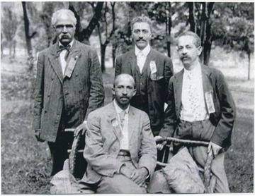 Seated is W.E.B. Du Bois. Standing, from left to right, is J. R. Clifford, L. M. Hershaw, and F. H. M. Murray.