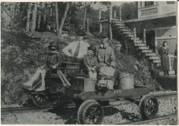W. L. Miller pictured with a railroad worker to his right. Raymond Miller picture in front and George Miller stands behind the motor car. Mullens girls seen in the background at the "RK" Cabin. Photo courtesy of George C. Miller.