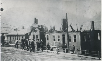 Unidentified men observe the damage after the fire.