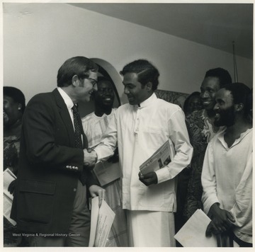 President Gee of West Virginia University, pictured on the left, congratulates Gamini Batuwitage from Sri Lanka on completing a year of study at WVU as one of eight Hubert Humphrey Fellows. With them is another Humphrey Fellow, Al Hassan Jagne(center) from Gambia. The federally financed fellowship program brings mid-career government officials from developing countries to the U.S. for a year of advanced study in agriculture, health administration, management and planning. 