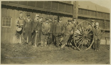 Group of men pose by the hose wheel. Subjects unidentified. 