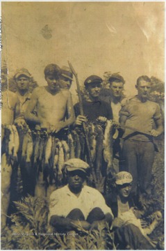 A group poses with their caught fish. Front row: "Black Bottom"; Orb Farley; Jack Sweeney. Back row, left to right: Ap Terry; Dempsey Keaton; Bob Payne; Fred McDaniels; unidentified; Paul Butler