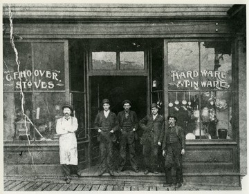 A group of unidentified men pose by the store front.