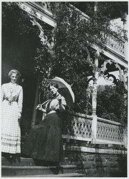 The two sisters, Laura on the left, pose on the front steps of the Cook home.