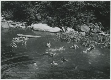 A group of unidentified boys play in the river.