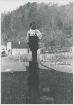 Kelly, Jr. pictured standing on top of a log.