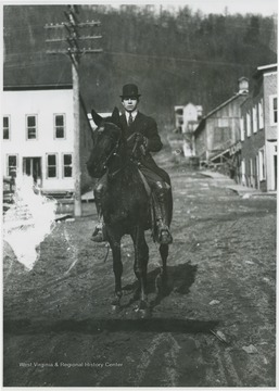 An unidentified man rides through town.