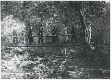 A group walks across the bridge. Subjects unidentified. 