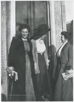 The two women are greeted by another unidentified woman.