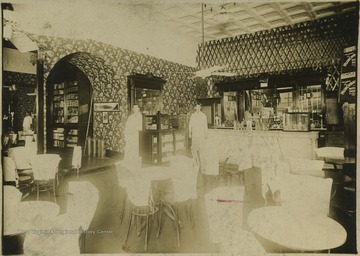 Interior of the store located at the corner of Temple Street and 3rd Avenue. Two employees are pictured in the back by the counter. Subjects unidentified. 