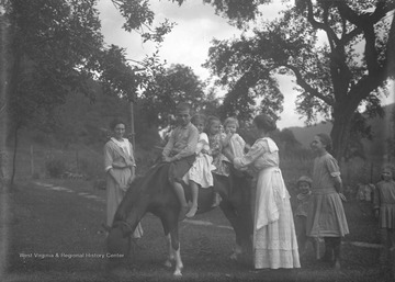 Woman to the left is Edith Taylor Green, woman placing child on pony is Roseanne Green (Uncle Charle's wife), taller girl to her right is Virginia Green, and boy beside her is Benton Green.