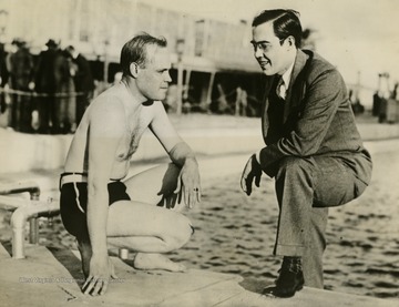 Caption on photograph reads: "It would seem that the senator from West Virginia is stepping from the Roney plaza swimming pool fully attired. Really Senator Rush Dew Holt, the youngest member of the Senate, is standing on a narrow walk around the pool as he chats with Harold K. Bradford, of Washington, D.C., retiring President of the National Association of Securities Commissioners. Senator Holt was in Miami to address the association's annual convention."