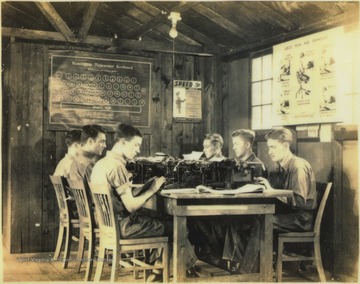 Six young men sit behind typewriters. The class cost 50 cents a month to participate in. Subjects unidentified. 
