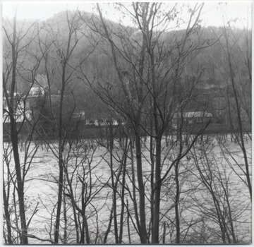 The water is just barely within reach of the homes. Pictured is either Greenbrier River or New River.