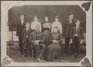 Mr. and Mrs. Thornton Gwinn sit in front of their standing sons and daughters.Mr. Gwinn was a native of Summers county who died suddenly at his home on August 17, 1934. Mrs. Gwinn died after long complications and ailments on June 30, 1937. The Gwinns were devout Catholics and survived by their children: Mrs. Frances Kincaid, of Hinton; Mrs. A. F. Campbell, of Raleigh; Mrs. J. L. Hurley, of Sandstone; J. A. Gwinn, of Sandstone; H. S. Gwinn, of Thurmond; E. W. Gwinn and George Gwinn.
