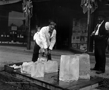 The Ice Man chips apart large blocks of ice.