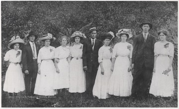 Lilly family members pose with Meador family members. The women wear matching white dresses.