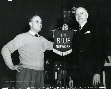 John L. Grimes was advertising executive of Wheeling Steel Corporation and was responsible for the creation of the "It's Wheeling Steel" radio broadcast in 1936. In 1941 the show was picked up by the National Broadcasting Company's Blue Network, as it grew in popularity, evident on the microphone stand. In 1943 the show took to the road throughout several cities in West Virginia to put on "Buy a Bomber" themed shows, where the host cities were challenged to buy enough enough Defense Bonds to purchase a medium or large sized bomber. Cities who accomplished the challenge would get their name placed on the plane as it flew to battle.