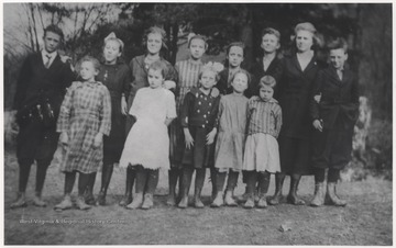 Teacher standing on the right is Sibyl Lilly, Gib Lilly's daughter. The boy to the left of the teacher is Perry Lilly. Boy to the right of the teacher is Carl Lilly. First girl on the far left is Lellie Lilly with Eva Meador next to her in a white dress. Third from the left on the back row is Euva Meador. The rest of the subjects are unidentified.The school was located about five miles up the Bluestone River from its mouth on the Pipestem side. 
