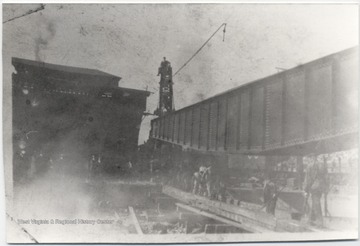 Unidentified workers construct a turn table outside of the roundhouse building. 
