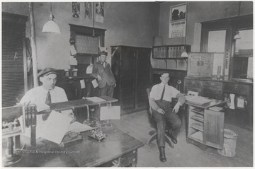 Three unidentified men are pictured inside the telegraph office, where the ticket office was later located. 