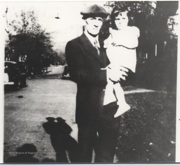 F. G. "Happy" Elmore, pensioned in 1945 and later died in 1954, is pictured holding his little girl. 