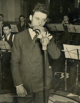 Ed Kostillo from the pipe mills of the Benwood Works started playing his harmonica to entertain his fellow mill men during lunch hour. Later he won a headliner appearance on the family broadcast with the entire steelmakers orchestra accompanying him.