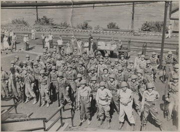 A group of unidentified soldiers stand in formation at the station.