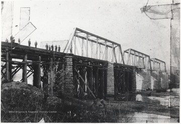 Workers pictured lined across the top of the bridge. Subjects unidentified.