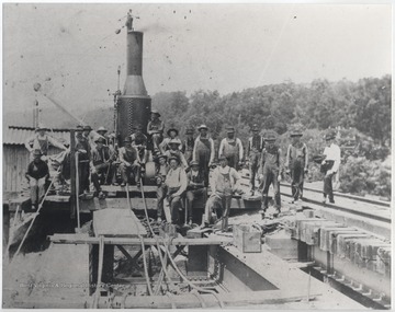 A group of unidentified workers are pictured beside construction equipment.