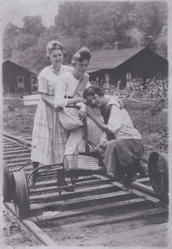 Three unidentified women are pictured with the railroad bicycle, or "velocipede".