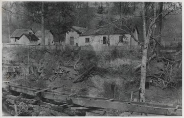 House pictured in the background. In the foreground is "Charlton's Mill Race", according to the description on the back of the photo.