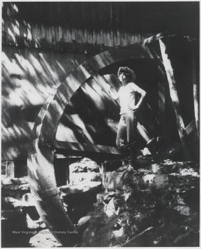 Daughter of then owner Owen Wills stands next to the water wheel.
