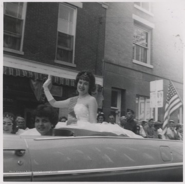 Unidentified parade queen (separate from the Centennial Queen) with female associates Lena Jane Bush (seated left) and Sissy O'Neal (seated right) make their way down Temple Street as part of the Centennial Parade.