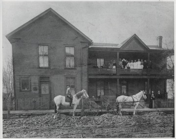 Doctors, patients and nurses stand on the balcony. On the ground level are John Frances and Mary Ellen "Mattie" Bigony. Dr. John Charleton Bignoy is pictured on the horse as a child. 