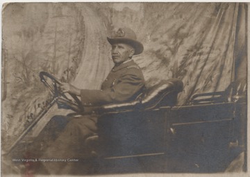 Chief of police McGhee is pictured in an old-fashioned automobile.