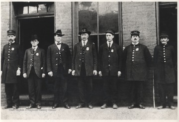 From left to right is Genie Briers, unidentified, Ernest Bruce, Chief J. L. McGhee, unidentified, H. Harry Peck, and an unidentified officer. 