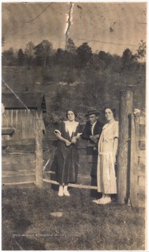 Two young women and a young man stand outside the Joyce Bragg Jarrell home. Subjects unidentified. 