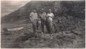From left to right is Edward Lanham, Conelius "Neil" Louis Burdette, and Calvin Cales. The boys hold fish they caught at the falls.