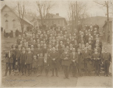 A group of members belonging to an unidentified church pose on its grounds. 