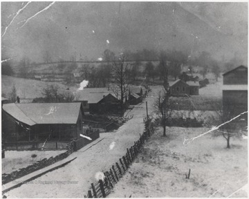 Photograph originally used as a post card. View of the snow covered town.