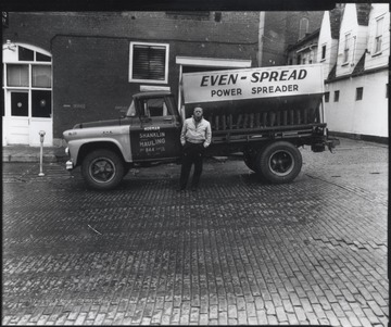 Shanklin pictured beside a truck that advertises "Norman Shanklin General Hauling. Even-spread power spreader."