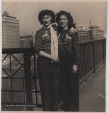 Ruth Smith Norris (left) and Eula Mae Garten (right) pose in Christmas sweaters. The Ruffner Hotel and the Union Building can be seen in the background.