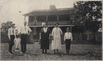 Pictured are the unidentified family members of Pack in front of their home in Jumping Branch District.