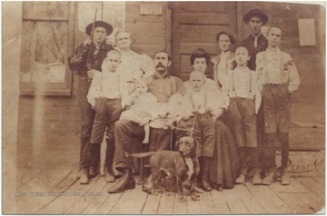 The Chattin family poses outside of their home with their pet dog.